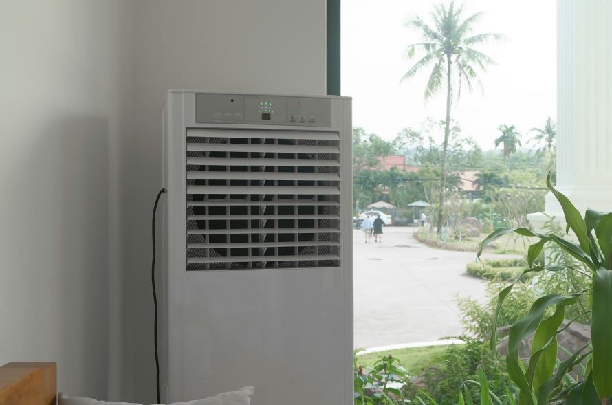 Răcitor de aer plasat într-o cameră, lângă geam - Avantajele unui răcitor de aer