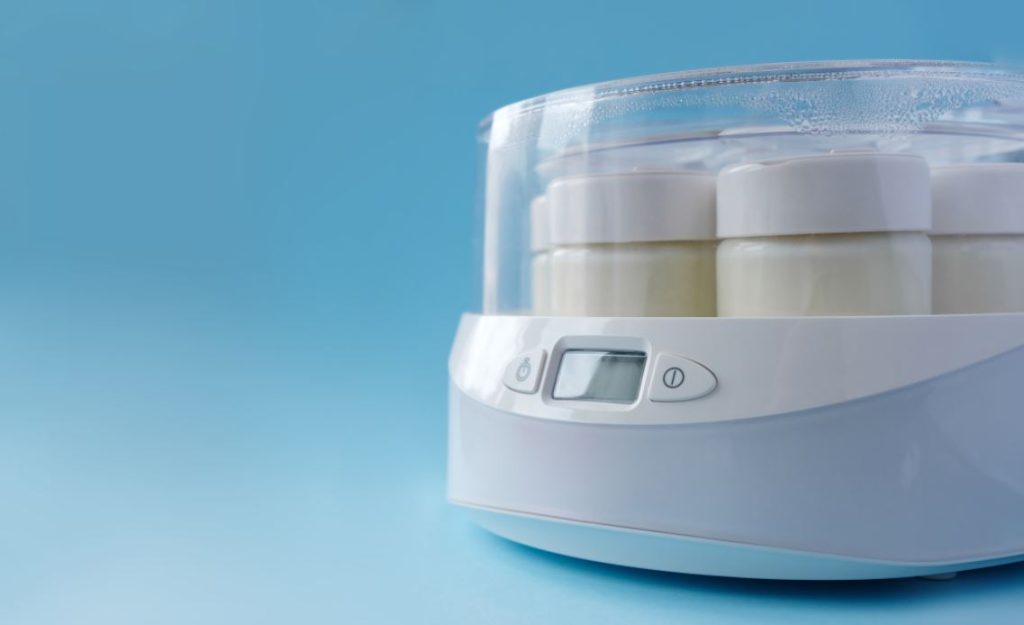 Aparat de făcut iaurt plin cu borcane, reprezentând top cele mai bune aparate pentru făcut iaurt