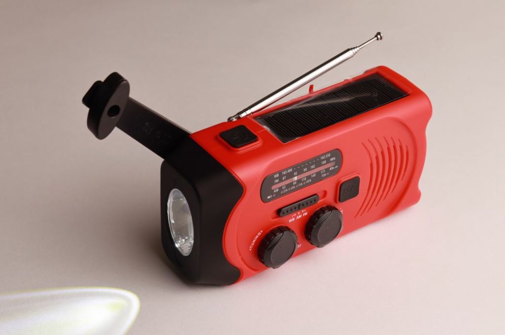 Radio portabil roșu cu manivelă reprezentând un model pentru Cel mai bun radio portabil